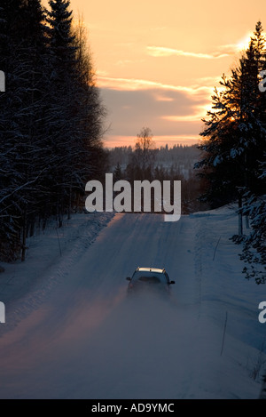 Auto fahren in einer verschneiten Seitenstraße am Abend im Winter, Finnland Stockfoto