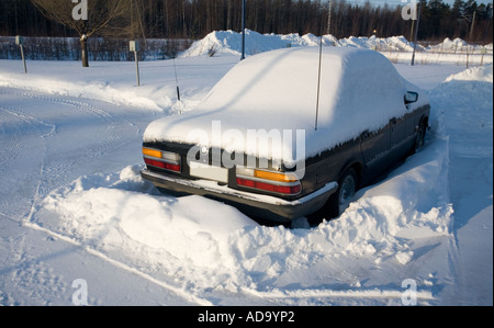 Geparktes Auto aufgeklebt Schneewehe, Finnland Stockfoto