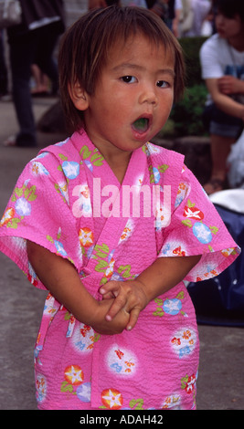 Junge japanische Kind trägt rosa Kimono gähnt. Japan. Stockfoto