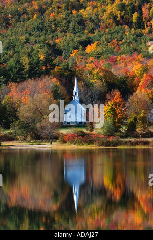 Kleine weiße Kirche Herbst Farbe reflektiert In Crystal Lake Eaton Center New Hampshire Stockfoto