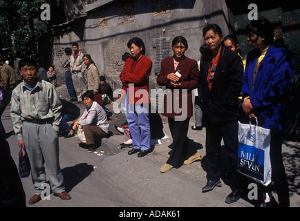 Peking China 1990er arbeitslose arbeitslose Männer und Frauen warten auf dem inoffiziellen täglichen Arbeitsmarkt, um für eine mögliche Arbeit ausgewählt zu werden 1998 HOMER SYKES Stockfoto