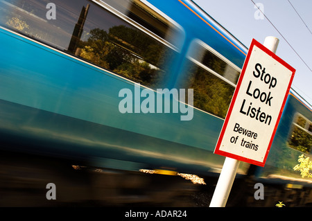 Zug durch eine Fußgängerzone Bahnübergang mit Warnschild Stockfoto