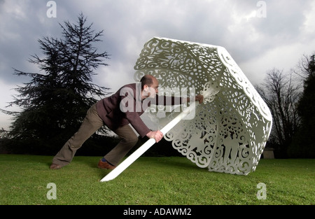 Bildhauer Bruce Williams ordnet seine Stahl Sonnenschirm im Garten des historischen Polesden Lacey in der Nähe von Dorking Surrey Stockfoto