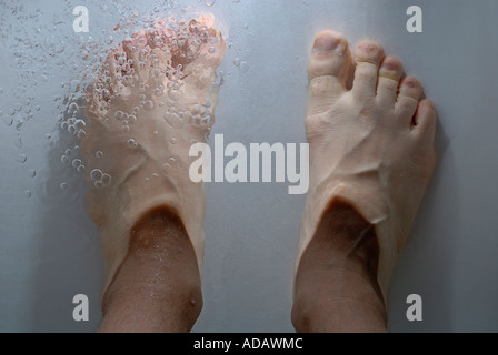 Die Füße des Menschen unter Wasser in einer Badewanne - Sicht. Stockfoto