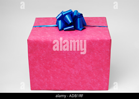 Geschenk verpackt mit rotem Papier und ein blaues Band Stockfoto