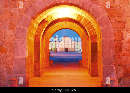 Nacht Blick vom mittelalterlichen Stadttor Puerta del Alcacer auf dem Platz Plaza Santa Teresa mit Kirche Iglesia de San Pedro, Avila, Stockfoto