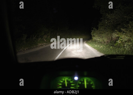 Treiber-Blick aus dem Inneren eines Autos fahren bei Nacht auf einer abgelegenen Landstraße Stockfoto