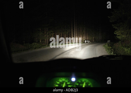 Treiber-Blick aus dem Inneren eines Autos fahren bei Nacht auf einer abgelegenen Landstraße Stockfoto