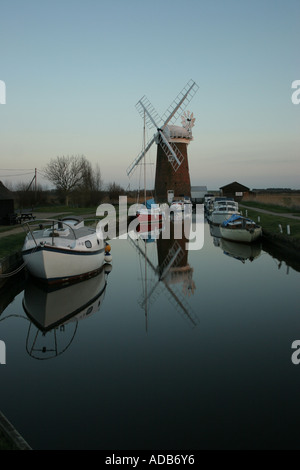 Reflexionen von Booten und Mühle in stilles Wasser Stockfoto