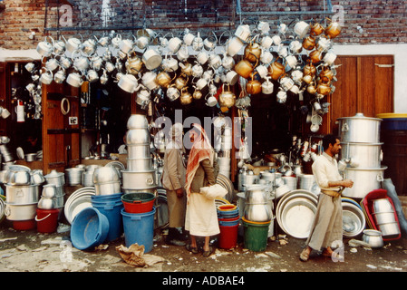 Zwei Männer Tauschhandel vor einem Hardware-Geschäft, dass verkauft Töpfe und Pfannen Gerichte Metall Kochen Geschirr in Jaisalmer, Rajasthan, Indien Stockfoto