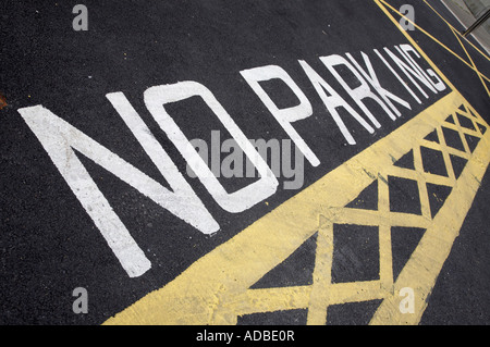 weiß, keine Parkplätze gemalt auf Asphalt zusammen mit gelben Box Kreuz Luken im Parkhaus Stockfoto