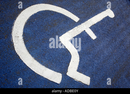 weißes Schild Behinderte übermalt blau lackierten Asphalt Farbasphalt in Behinderten Parkplätze Bucht auf Parkplatz Stockfoto