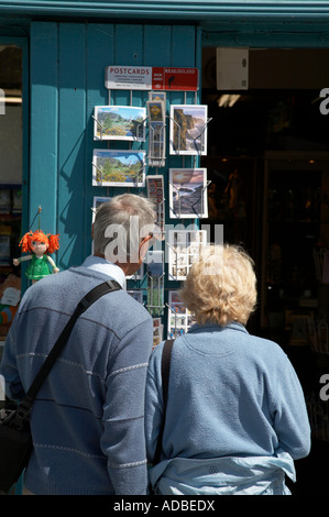älteres Ehepaar betrachten Postkarte anzeigen außerhalb einer Tourist-Souvenir-Shop in Avoca Grafschaft wicklow Stockfoto