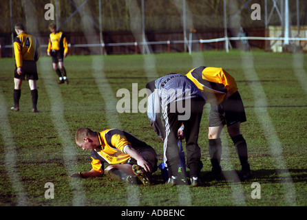 Ein Fußballer für ein Bein Verletzungen während einer Amateur-Spiel, Stowemarket, Suffolk, UK behandelt. Stockfoto