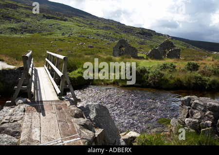 neue Holzbrücke über den kleinen Bach zu ruiniert alte Kirche neben St Kevins Straße in die Wicklow Mountains Stockfoto