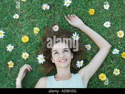 Frau mit Blumen auf dem Rasen liegen verstreut um Kopf Stockfoto