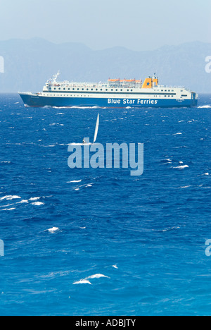 Vertikale Ansicht von einer großen griechischen Auto- und Fähre in der gleichen Strecke von Wasser als eine kleine weiße Yacht Segeln Stockfoto