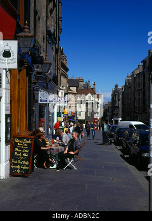 dh Hautpstraße ROYAL MILE EDINBURGH Menschen im freien Straßencafé Pflaster Stockfoto