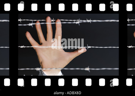 Blick auf den Strip konzeptueller Film von Hand Griff nach Stacheldraht im Gefängnis Palisaden Stockfoto
