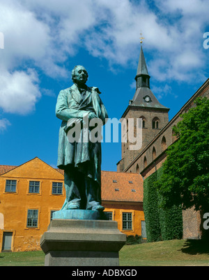 Statue von Hans Christian Anderson, mit Skt knuds domkirke (Kathedrale), Odense, Fyn (Fünen), Dänemark. Stockfoto