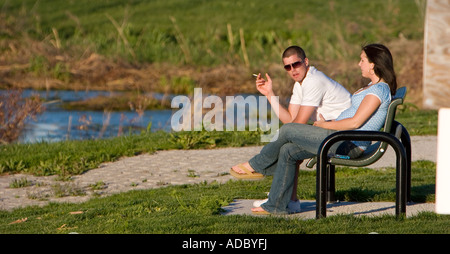 Ein Mann und eine Frau sitzen auf einer Parkbank in Holmes Lake in Lincoln, Nebraska, USA. Stockfoto