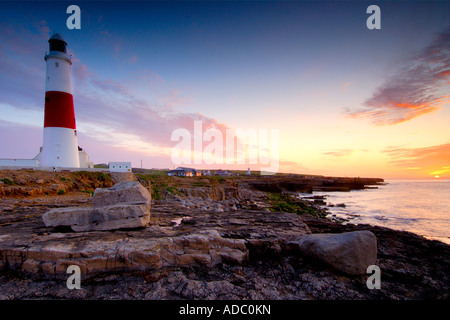 Portland Bill Leuchtturm in der Dämmerung aus dem vorland unter den tückischen Landspitze Felsen, die das Meer bei Ebbe Stockfoto