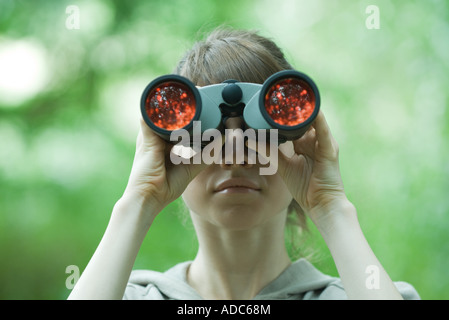 Frau, die durch ein Fernglas Stockfoto