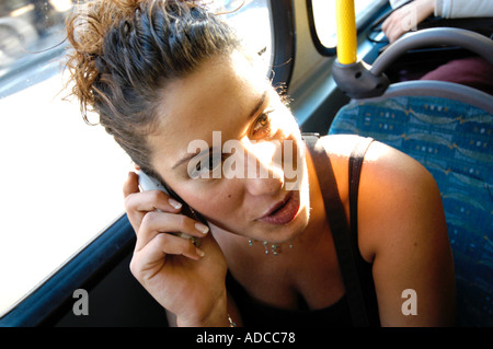 Moderne junge Türkin telefonieren mit Handy auf Bus in London England UK Stockfoto
