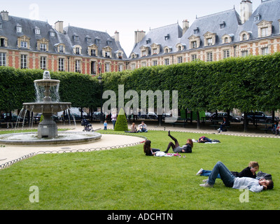 Menschen, die Entspannung und Spaß im Park am Place des Vosges Le Marais Viertel Paris Frankreich Stockfoto