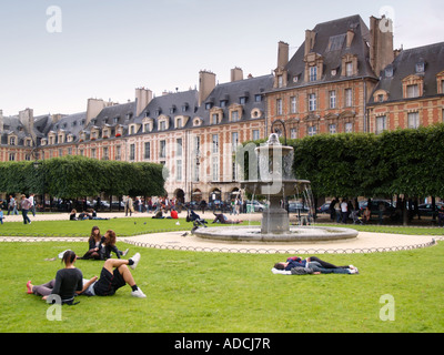Menschen entspannen in der Place des Vosges Park Le Marais Paris Frankreich Stockfoto