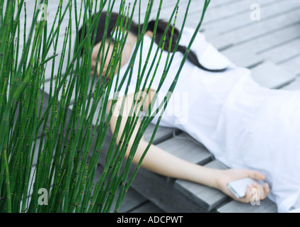 Frau liegend auf decking Kopfhörer anhören Stockfoto