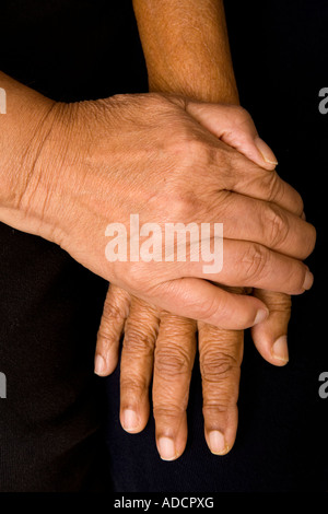 Ein älterer asiatischen Mann legt seine Hände auf die Hand seiner Frau auf beruhigende Weise. Stockfoto