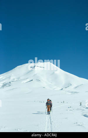 Skifahrer bergauf gehen Stockfoto