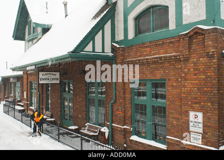 Ein Stadt-Arbeiter Schaufeln Schnee an der Flagstaff Visitor Center und Bahnhof im Winter befindet sich auf der historischen Route 66 in Nord- Stockfoto