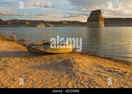 Ein Boot am Strand bei Sonnenaufgang am Lake Powell mit Lone Rock im Hintergrund Stockfoto