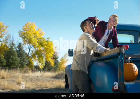 Applying Frauen sitzen im Bett eine alte blaue Pickup-Trucks Fütterung einen Apfel, einem Mann steht neben dem Stockfoto