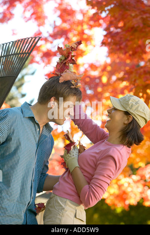 glücklich Anfang 30 kaukasische paar spielen im Herbst Blätter Stockfoto