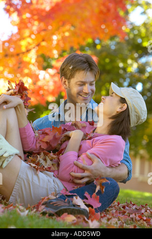 glücklich Anfang 30 kaukasische paar spielen im Herbst Blätter Stockfoto