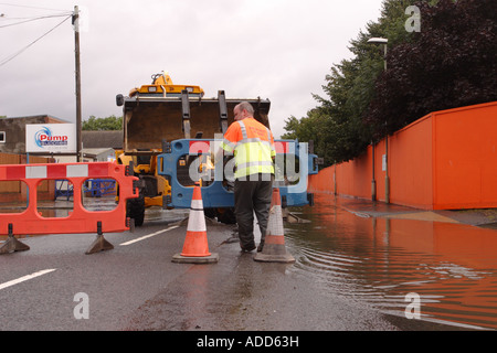 Überschwemmungen in Gloucester in England Juli 2007 Gemeindeverwaltung Rates Arbeiter Straße Schließung Barriere auf der überfluteten Straße aufstellen Stockfoto