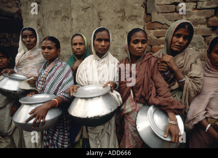 Arme Menschen mit Töpfen Schlangestehen für Lebensmittel für ihre Familie bei Mutter Teresa s Mission Kalkutta Indien Stockfoto
