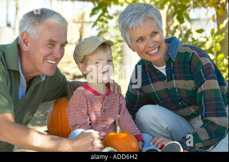 Kaukasische senior Großeltern mit Enkel im Kürbisfeld im Herbst Stockfoto