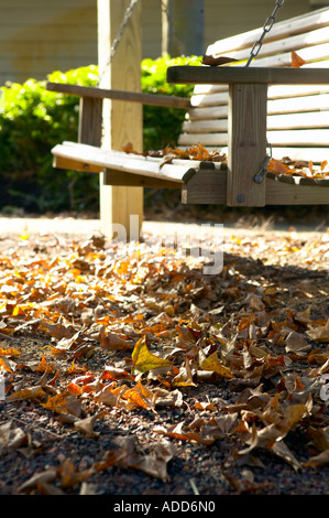 Veranda-Schaukel abgedeckt im Herbstlaub Stockfoto