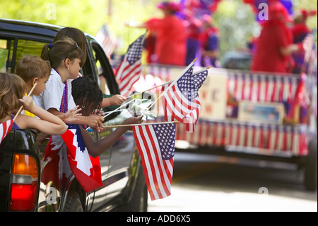 Kinder Multi Rennen wehende Fahnen auf der Rückseite einen Pickup-Truck, während ein 4. Juli parade in Brooklin, Maine Stockfoto