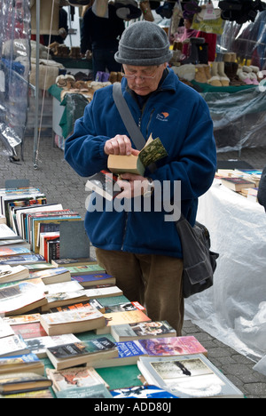 Ein älterer Mann, der einen Bücherstand aus zweiter Hand auf dem Salamanca Market in Hobart durchsucht Stockfoto