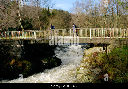 Wanderer überqueren die Brücke über den Fluss Irfon in der Nähe von Llanwrtyd Wells Powys Wales UK Stockfoto