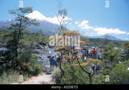 Gruppe von Touristen und Ausflügler, die Blick auf den Vulkan Osorno und den Fluss über einen kleinen Wasserfall, Chile, Stockfoto