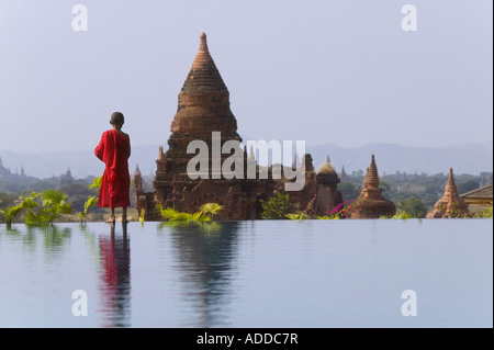 Mönch in rotem Gewand mit Pagoden von Bagan Myanmar Seerosenteich Stockfoto