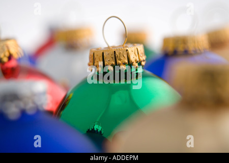 Nahaufnahme des grünen Weihnachtsbaum Birne Ornament gestapelt neben anderen bunten Ornamenten auf weißem Hintergrund Studioportrait Stockfoto