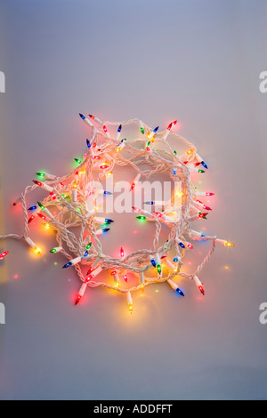 Ein Strang der bunten Weihnachtsbaum Lichter zusammen mit blauen Farbton dunkler Studioportrait aufgerollt Stockfoto