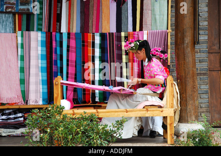 Eine junge Frau in traditionellen Naxi Kleid Handweberei Schals in der Altstadt Lijiang, Provinz Yunnan, China Stockfoto